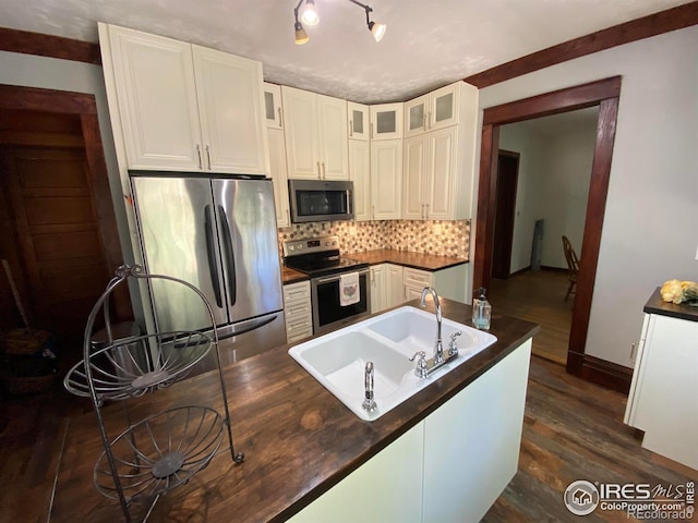 kitchen featuring white cabinetry, appliances with stainless steel finishes, sink, and decorative backsplash