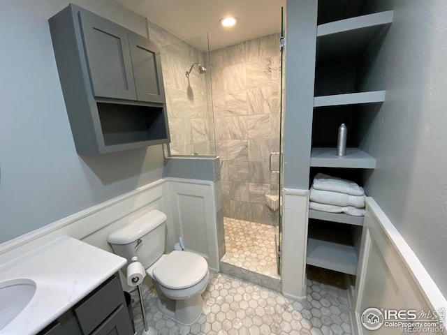 bathroom featuring vanity, an enclosed shower, and toilet