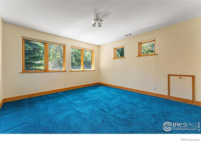 unfurnished room featuring dark carpet and ceiling fan