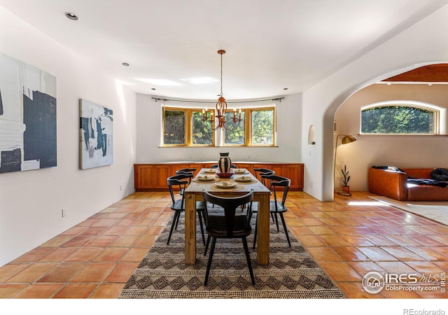 tiled dining room featuring an inviting chandelier