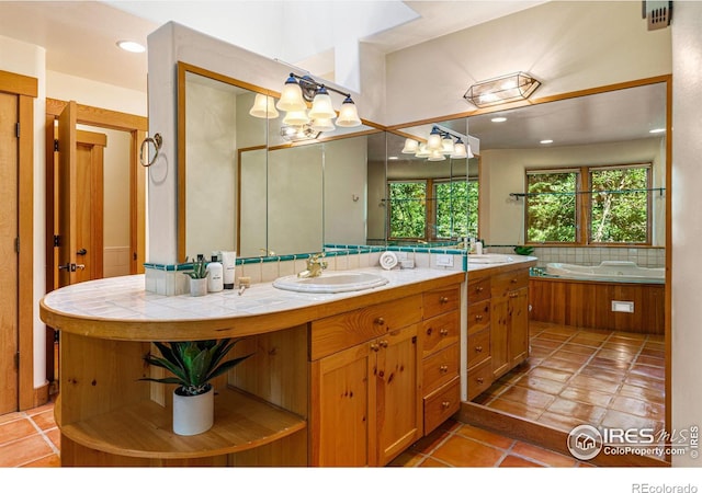 bathroom featuring tile patterned flooring, vanity, backsplash, and a tub