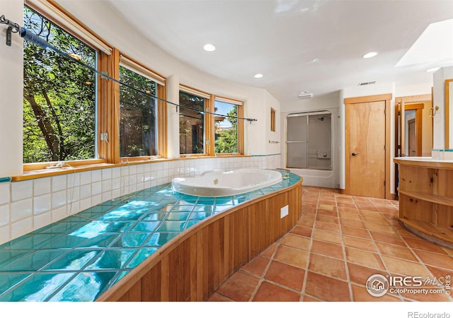 bathroom with tile patterned flooring, vanity, and a tub to relax in