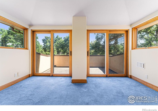 carpeted spare room with lofted ceiling