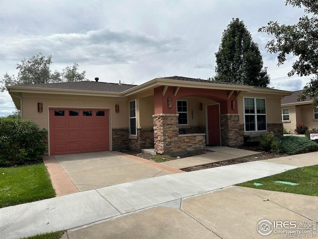 view of front of home featuring a garage, concrete driveway, stone siding, and stucco siding