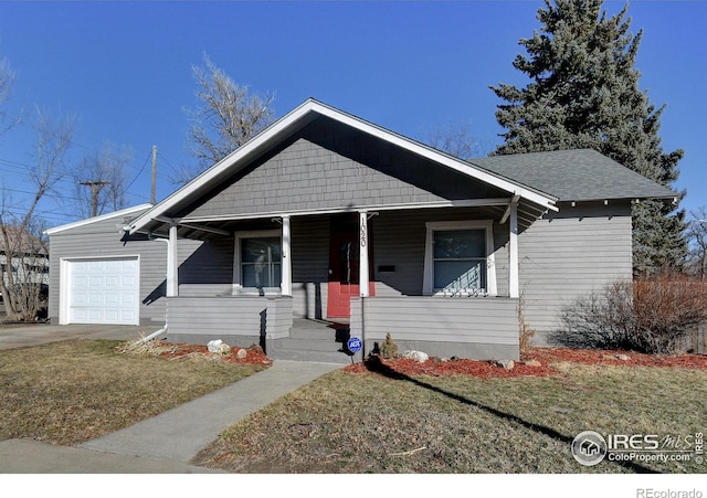 bungalow with covered porch, a front yard, and a garage