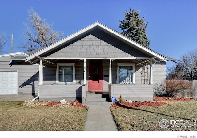 bungalow-style house featuring a porch, a front lawn, and a garage