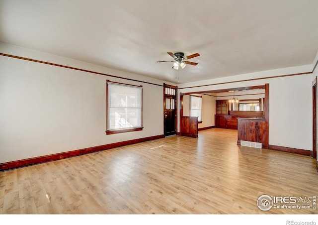 unfurnished living room with light hardwood / wood-style floors and ceiling fan with notable chandelier