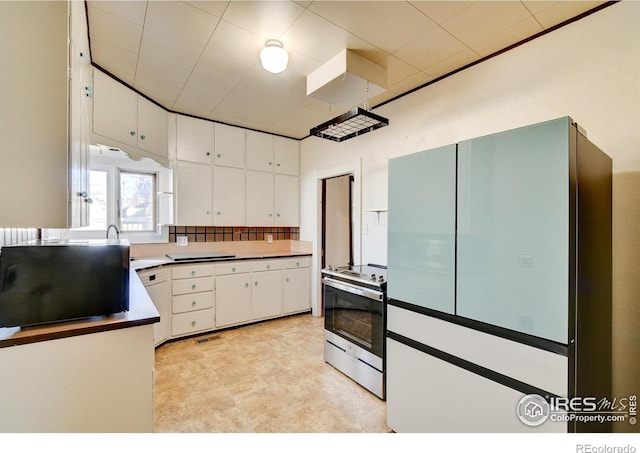 kitchen featuring white cabinetry, sink, electric stove, and light tile floors