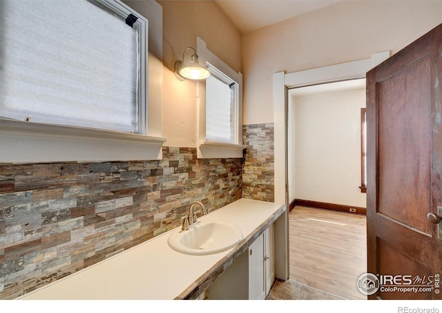 bathroom featuring tasteful backsplash, hardwood / wood-style flooring, and large vanity