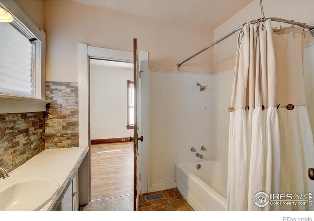 bathroom featuring plenty of natural light, vanity, shower / bath combo, and tile flooring