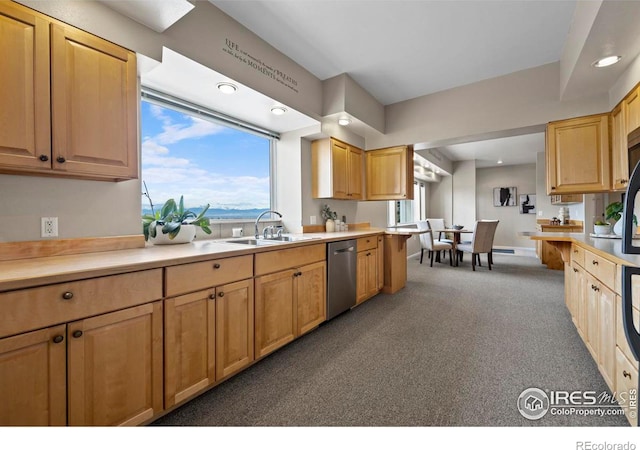 kitchen with dark colored carpet, dishwasher, sink, and a wealth of natural light