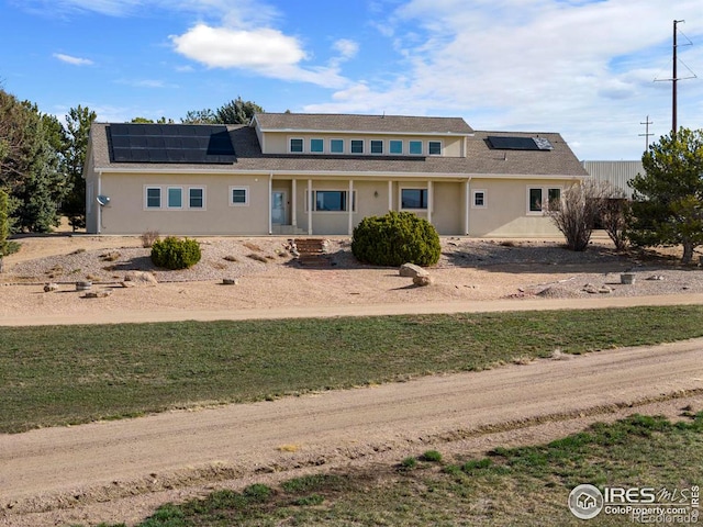 view of front of house with a front lawn and solar panels