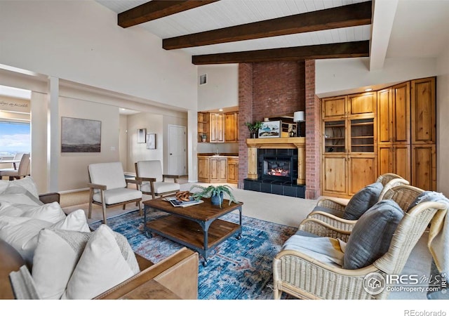 living room featuring a tiled fireplace, high vaulted ceiling, and beamed ceiling