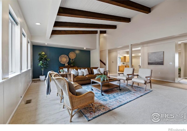 living room with light carpet and vaulted ceiling with beams