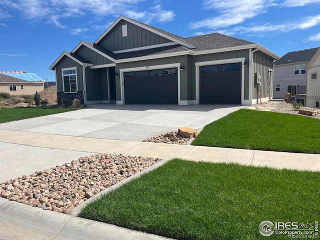 view of front of property with an attached garage, board and batten siding, concrete driveway, and a front lawn