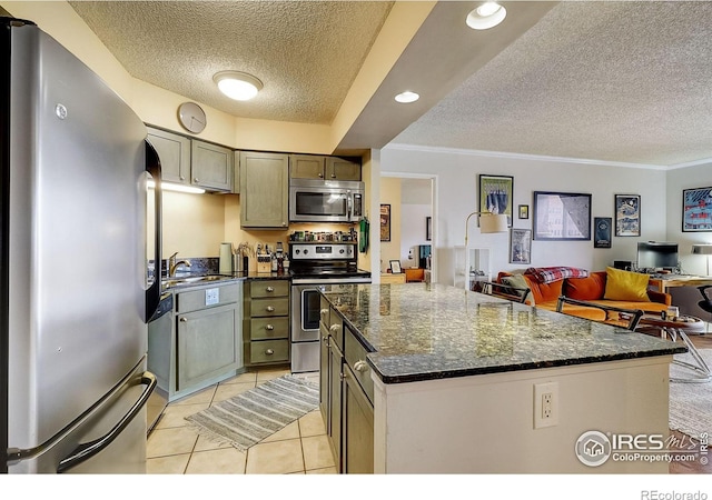 kitchen featuring a center island, appliances with stainless steel finishes, a textured ceiling, and light tile floors