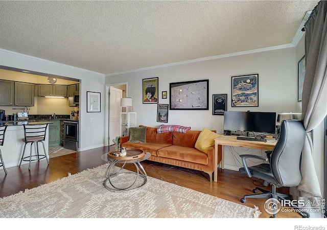 living room featuring ornamental molding, wood-type flooring, and a textured ceiling