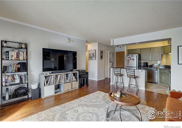 living room with crown molding, light hardwood / wood-style flooring, and a textured ceiling