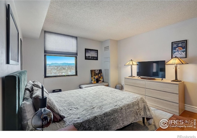 bedroom featuring wood-type flooring and a textured ceiling