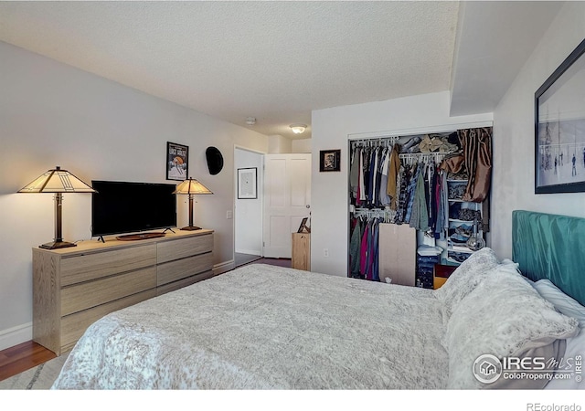 bedroom featuring a closet, a textured ceiling, and hardwood / wood-style floors