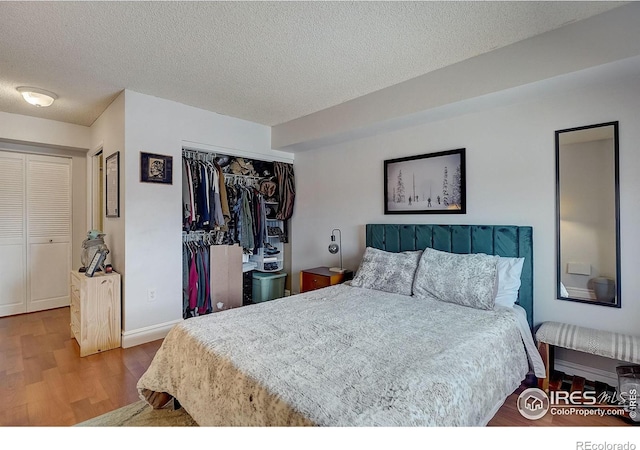 bedroom featuring wood-type flooring, a closet, and a textured ceiling