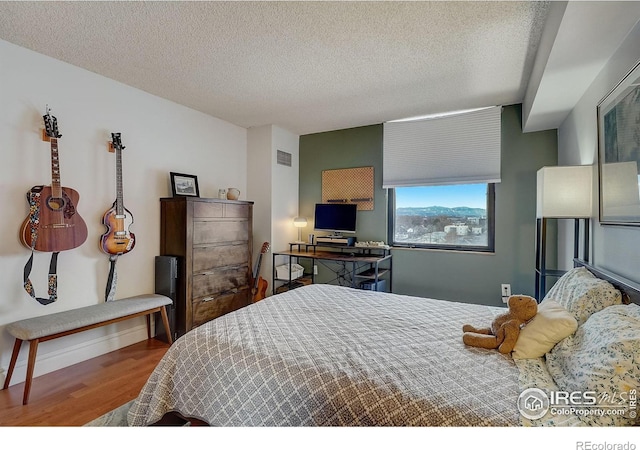 bedroom featuring hardwood / wood-style flooring and a textured ceiling