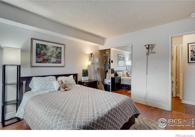 bedroom featuring hardwood / wood-style floors and a textured ceiling