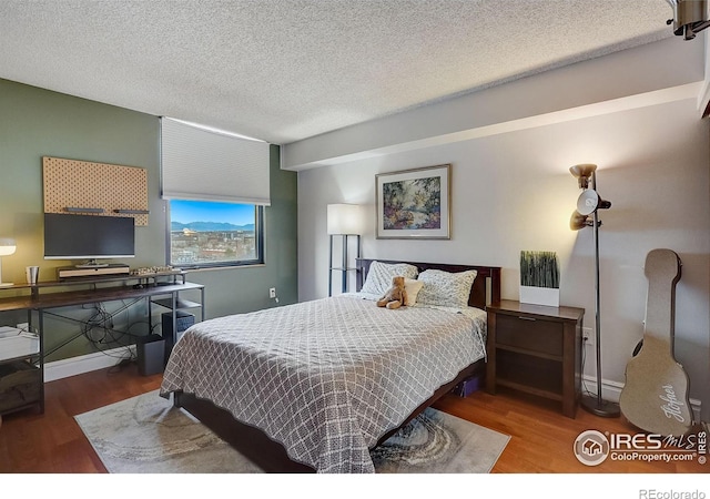 bedroom with wood-type flooring and a textured ceiling