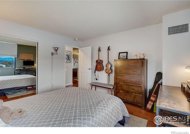 bedroom with hardwood / wood-style flooring and a textured ceiling