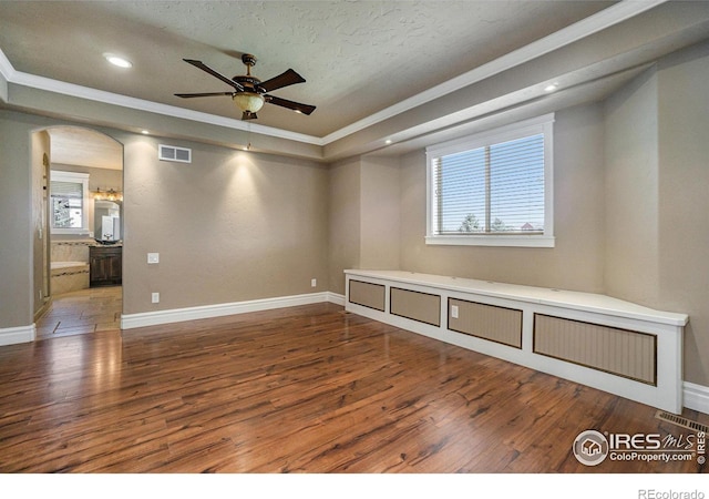 unfurnished room featuring ornamental molding, ceiling fan, a textured ceiling, and dark hardwood / wood-style flooring