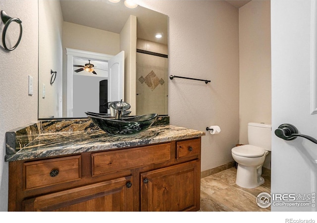 bathroom with walk in shower, vanity, toilet, and ceiling fan