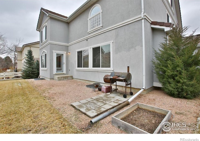 back of house with a patio area and a lawn