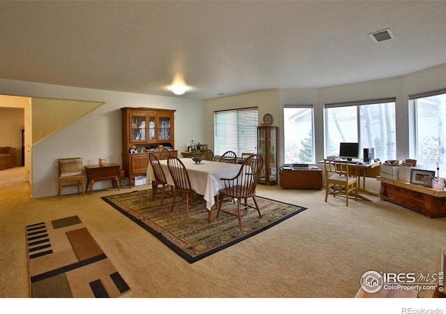 dining space with plenty of natural light and light colored carpet