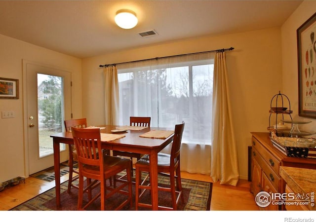 dining room with a healthy amount of sunlight and light hardwood / wood-style flooring