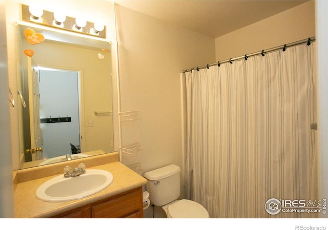 bathroom featuring vanity, toilet, and a shower with shower curtain