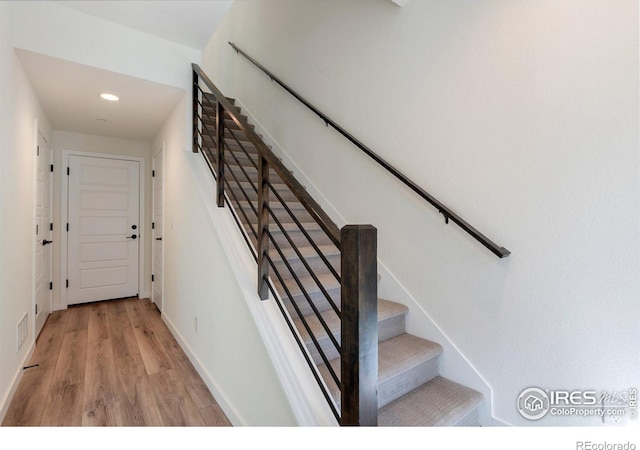 staircase with hardwood / wood-style floors