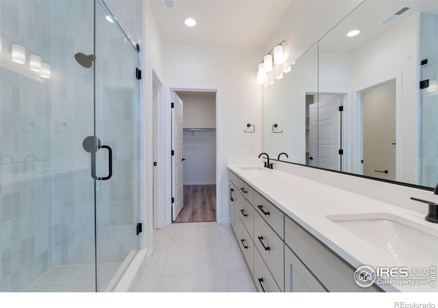 bathroom with hardwood / wood-style floors, vanity, and an enclosed shower