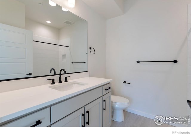 bathroom with hardwood / wood-style flooring, vanity, and toilet