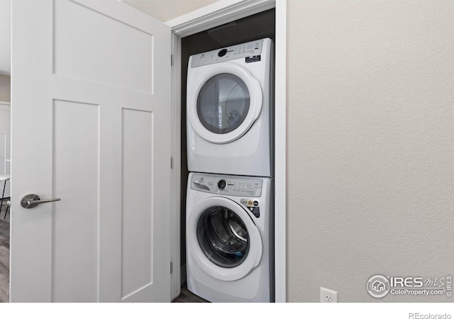 washroom featuring stacked washer / drying machine