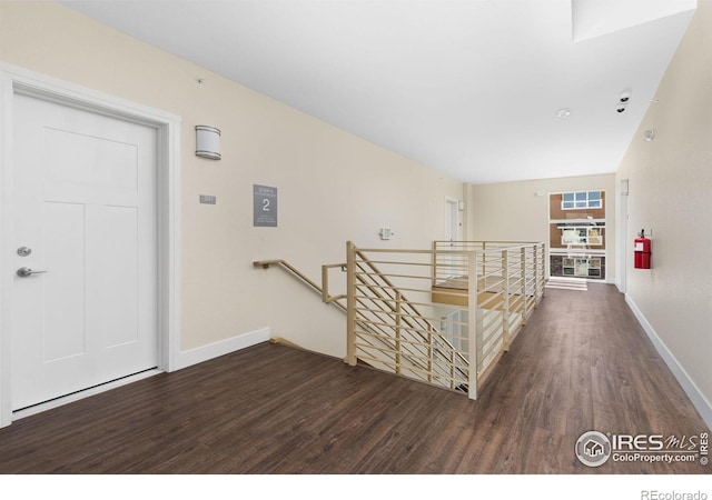 hallway with dark hardwood / wood-style flooring