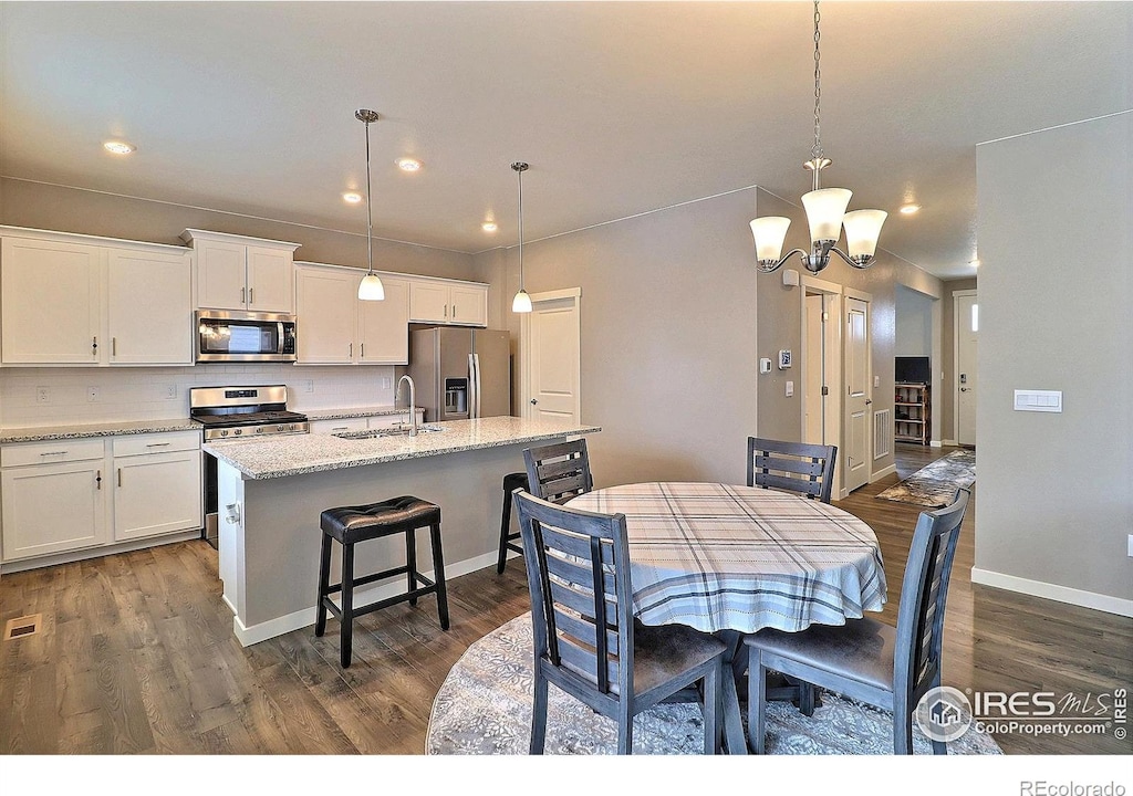 dining area featuring a notable chandelier, dark hardwood / wood-style floors, and sink