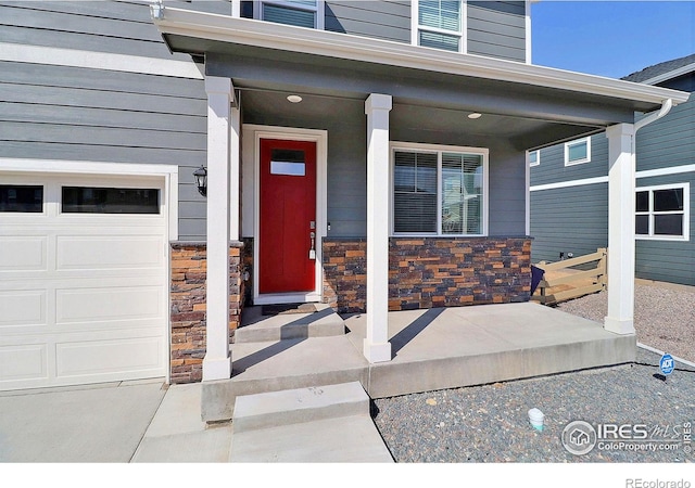 doorway to property featuring covered porch and a garage