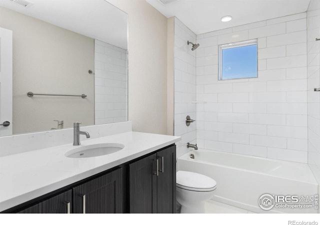 full bathroom featuring toilet, tiled shower / bath, and vanity