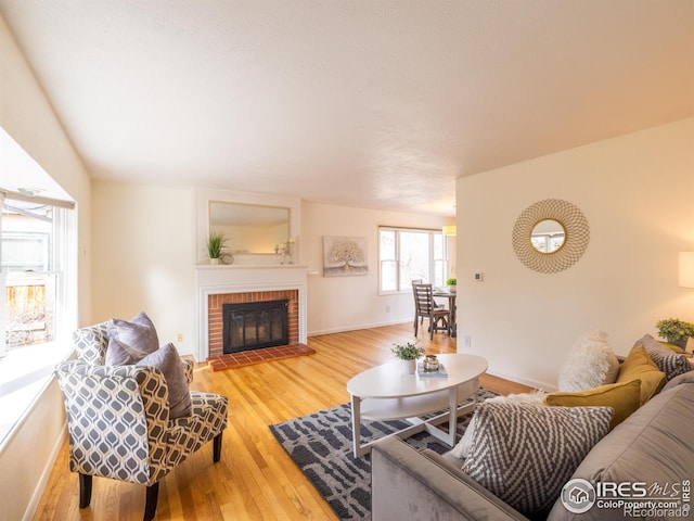 living room featuring hardwood / wood-style flooring and a brick fireplace