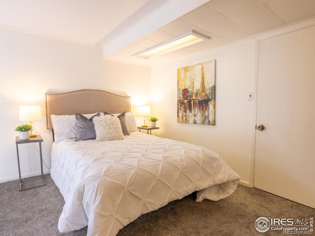 bedroom featuring carpet flooring, beam ceiling, and ornamental molding