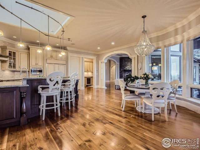 dining space with hardwood / wood-style flooring, a notable chandelier, and ornamental molding