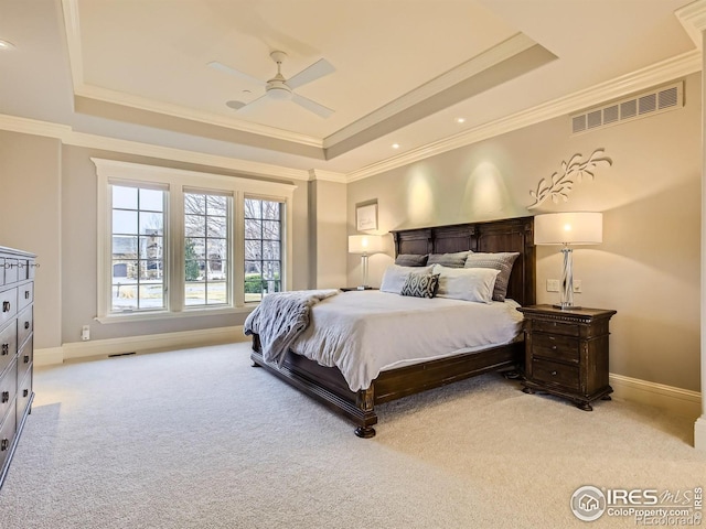 carpeted bedroom featuring a tray ceiling, ceiling fan, and crown molding