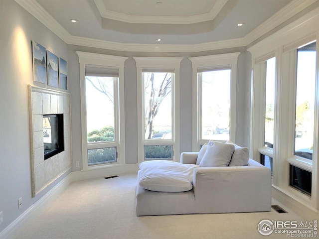 sitting room with a raised ceiling, ornamental molding, and light carpet