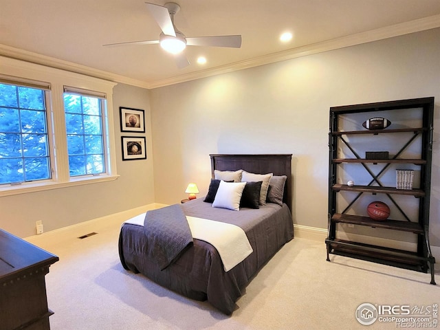 carpeted bedroom featuring ceiling fan and crown molding