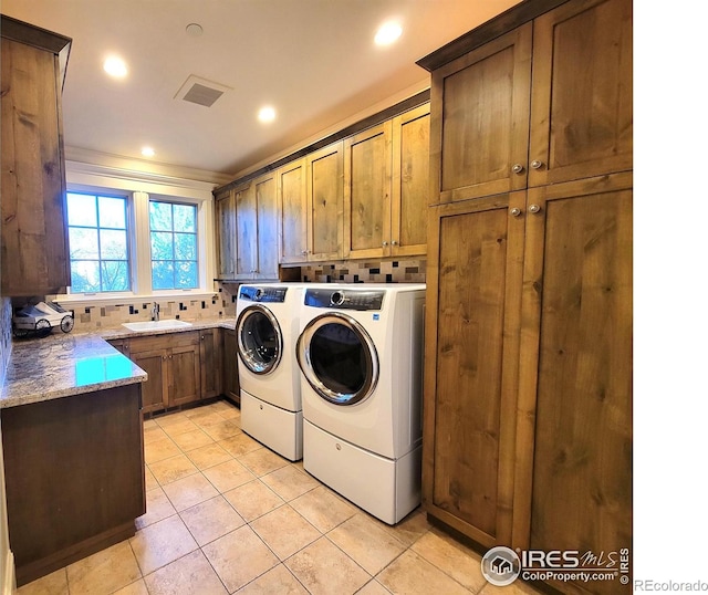 laundry area featuring ornamental molding, sink, cabinets, washer and dryer, and light tile patterned floors